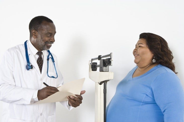 African American male doctor taking weight measurements of an overweight female patient, Picture