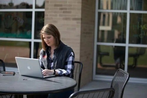 Student sitting outdoors on her computer, Picture