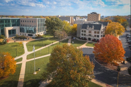 Aerial view of the Bradley University campus in autumn, featuring modern and historic buildings and vibrant fall foliage.